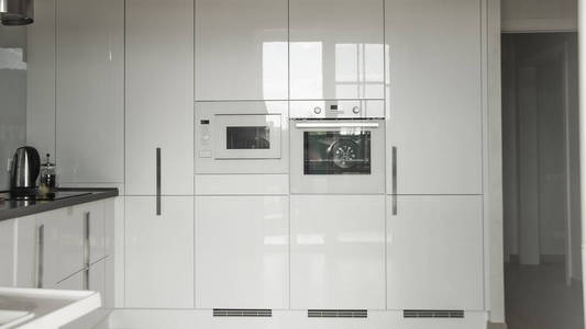 住宅中的现代厨房。 白色现代厨房内部，内置电器