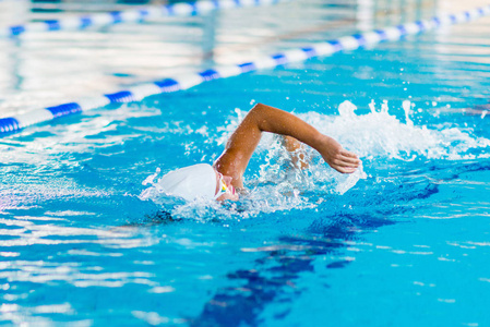 女游泳运动员正在游泳池训练. 前爬行游泳风格照片