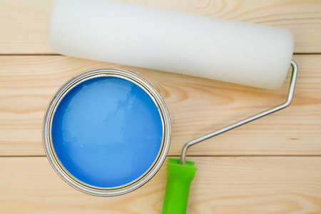 一罐蓝色油漆和一把油漆滚筒