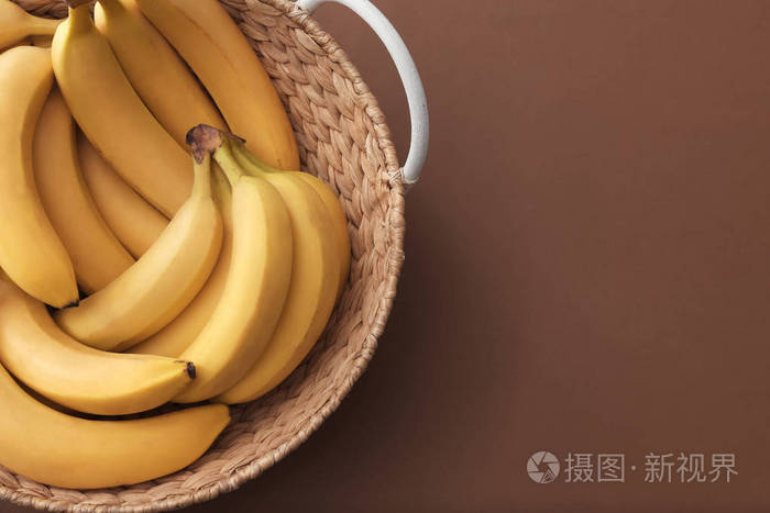 篮子与可口成熟香蕉在颜色背景