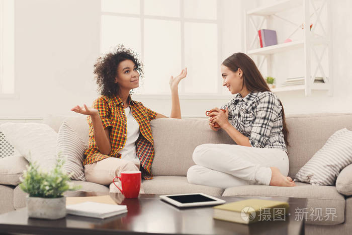 两个年轻的女性朋友与咖啡交谈