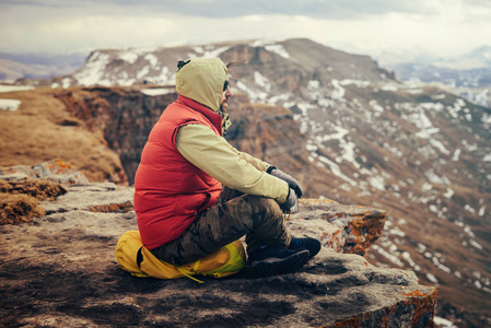 一个人在敞篷坐在山的边缘和享受自然