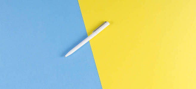 黄色和蓝色背景白色圆珠笔顶部视图