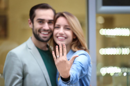 年轻男子和他的未婚妻显示订婚戒指