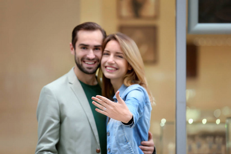 年轻男子和他的未婚妻显示订婚戒指