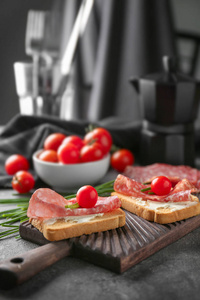 美味的三明治与意大利香肠和樱桃西红柿在木板