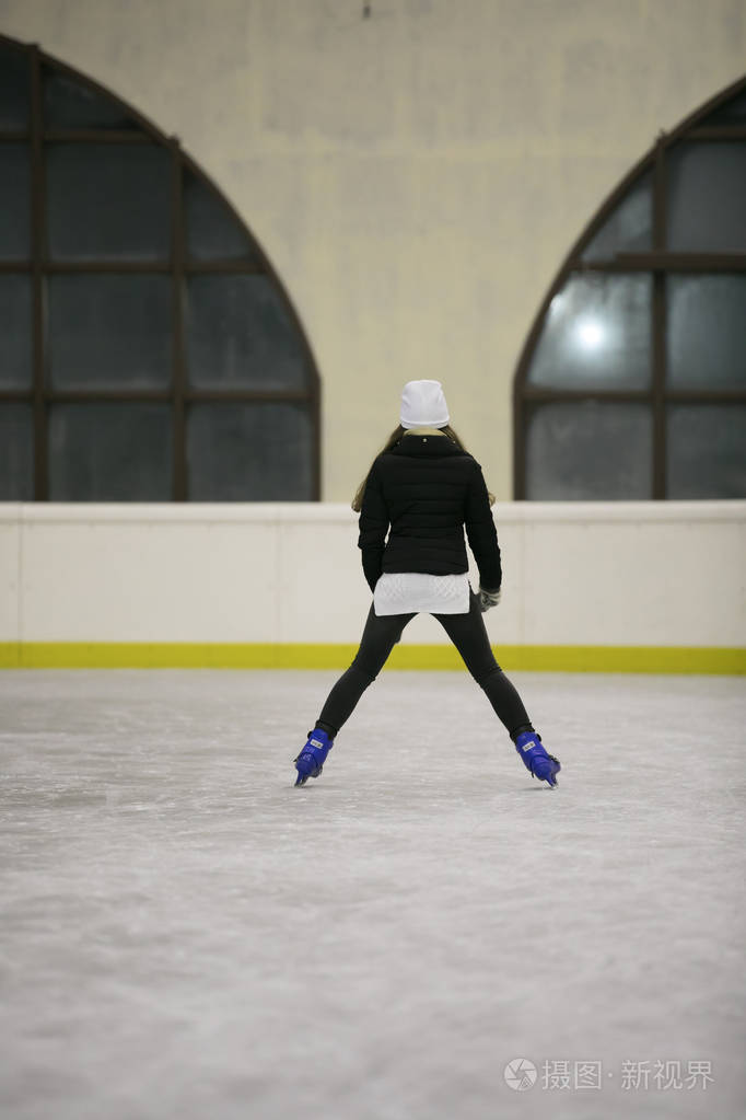 愉快的妇女滑冰在溜冰场后方看法