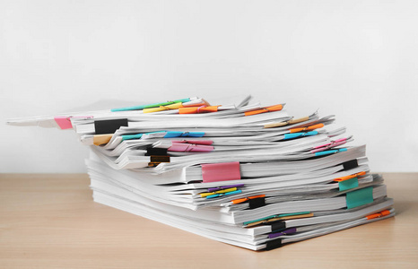 文员剪辑一堆文件放在桌子上,背景为白色照片