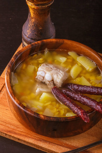 用土豆 排骨和腌的香肠木制板中的豌豆汤。特写
