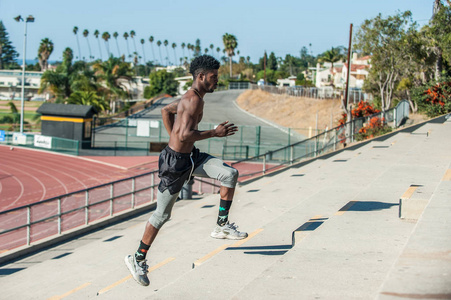 肌肉发达的牙买加运动员在冲刺体育场楼梯时获得了动力。