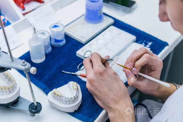 牙科技师或牙科医生在他的实验室中使用牙齿假牙