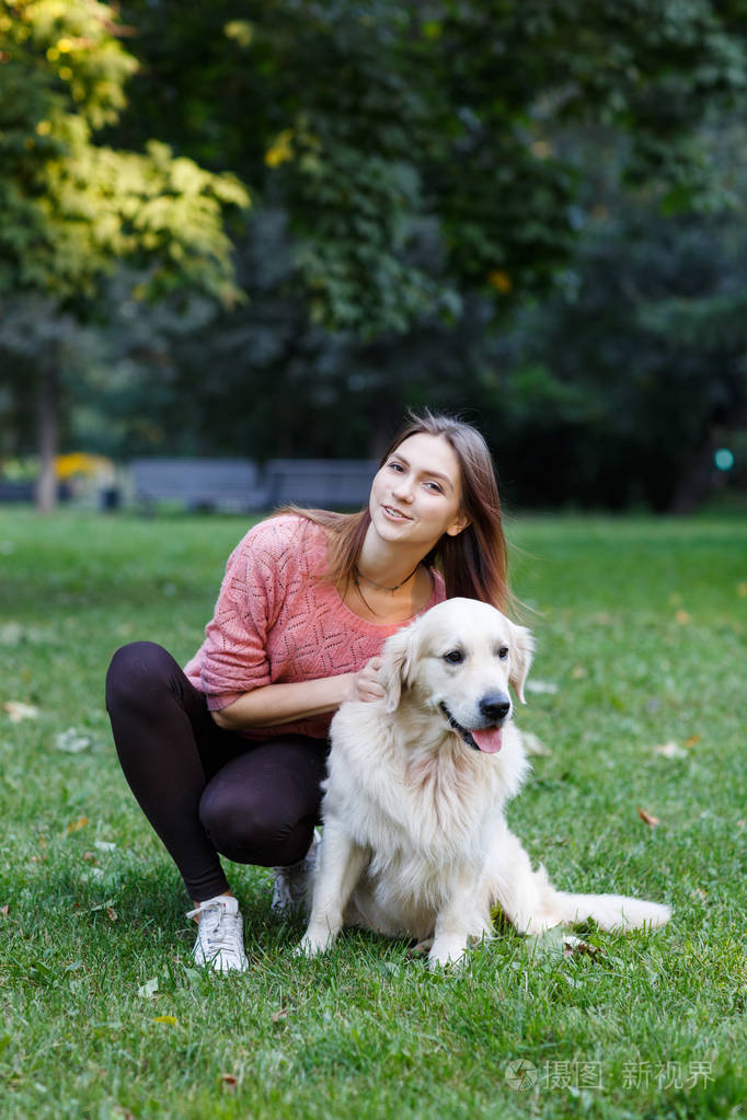 绿色草坪上的女孩抱狗形象