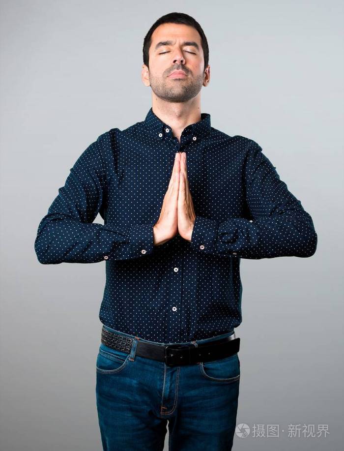 英俊的人恳求灰色背景