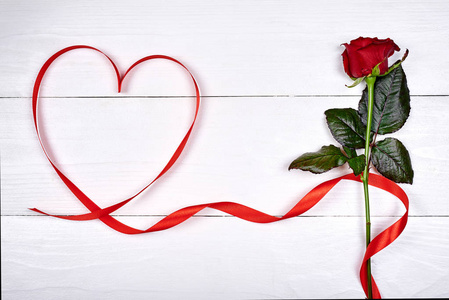 情人节背景与一个红色玫瑰和丝带形状的心脏复制空间。 情人节妇女日3月8日母亲节贺卡模型。 爱情婚礼的概念