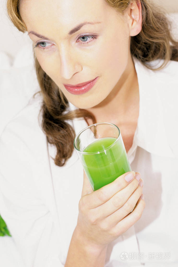 女人拿着饮料看着远处