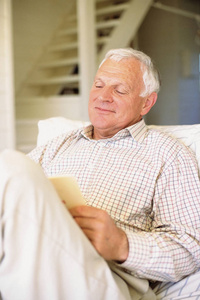 微笑的老人坐着看书图片