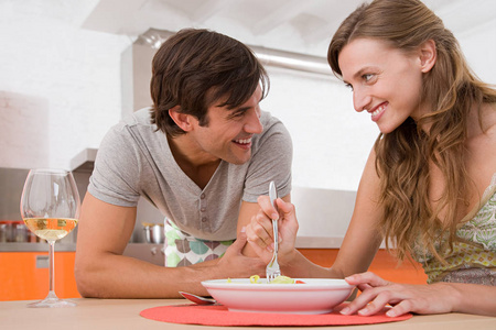 年轻迷人的白种人夫妇吃晚饭，互相看着对方