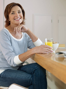 一位年长妇女正在吃早餐和看镜头的画像