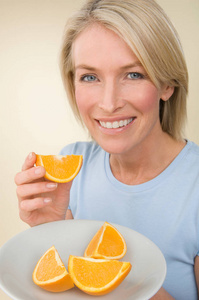 相当健康的白种人女人在米色背景下拿着一盘橙色的盘子