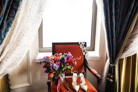 新娘早上的细节。婚礼花束和漂亮的女性鞋在老式椅子上