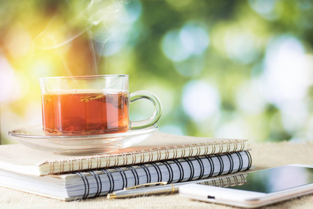 木桌上的热玻璃茶在早晨饮用时间