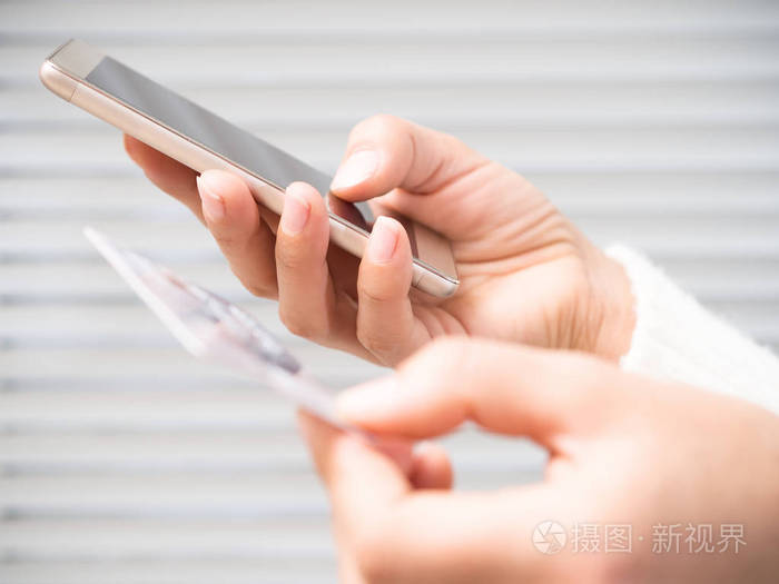 拿着电话和银行卡的女人的手
