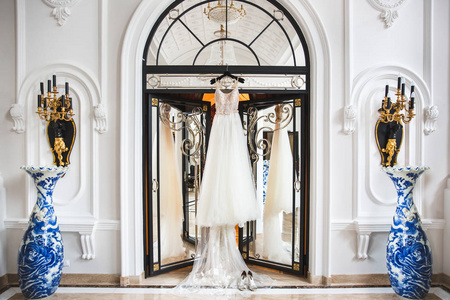 挂在白色房间的门上的婚纱礼服照片