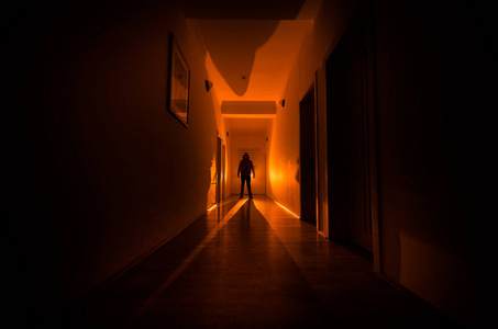 黑暗的走廊与内阁门和灯光与幽灵般的恐怖的人站在不同的姿势的剪影