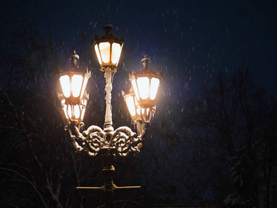 冬夜路灯随雪飘落。晚上公园的灯笼。圣诞节美丽的降雪。雪花飘落在神奇的城市。圣诞节和新年