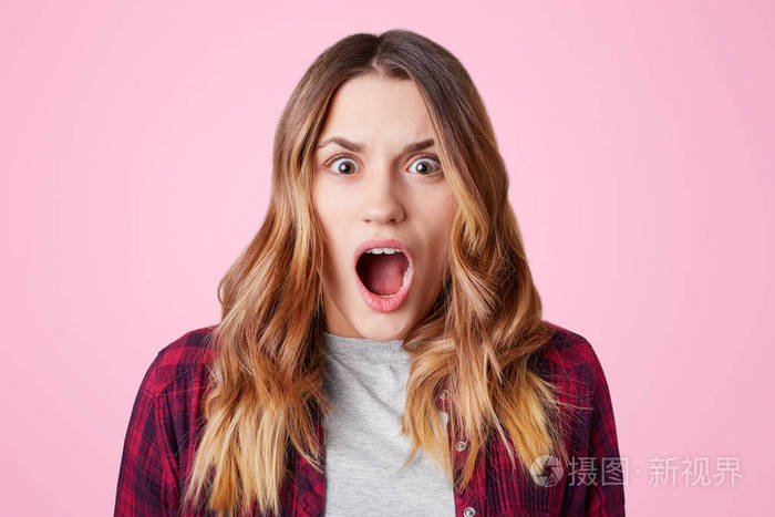 惊呆了的女学生张开嘴巴惊讶地知道明天是期末考试穿格子衬衫隔着粉色