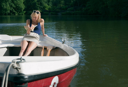 有吸引力的年轻白种人女人读关于划艇的书