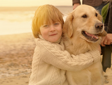小男孩拥抱狗。 海滩