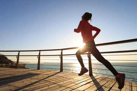 女子在日出小径上奔跑身材好的女人在健身室训练女运动员在路上跑步