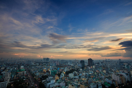 无尽的深蓝的天空,美丽的橙色的云彩,在大城市上空,在日落时分,高楼