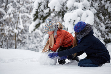 冬天的乐趣。一个女孩和一个男孩在做雪球