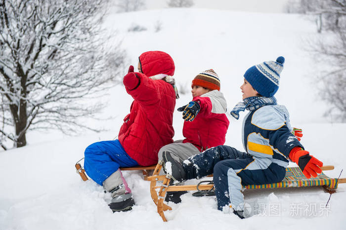 快乐顽皮的孩子在雪地里雪橇