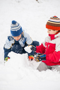 活泼可爱的孩子们在雪地里雪橇和堆雪人