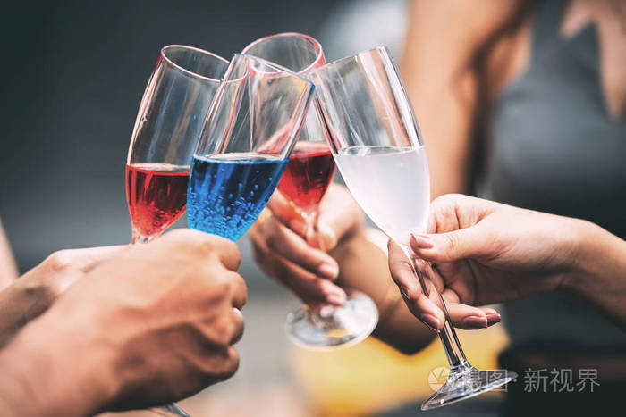 朋友手拿香槟酒杯祝酒在真正的酒吧环境中拍摄