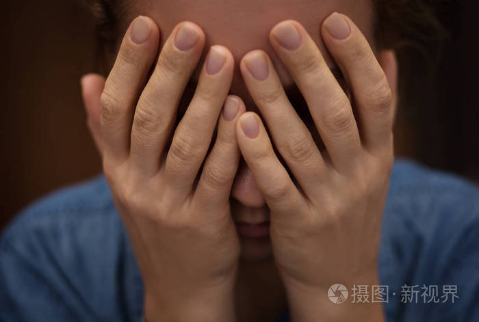悲伤的女人用双手遮住脸