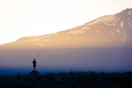 山背景下的一个人的阳光和剪影照片