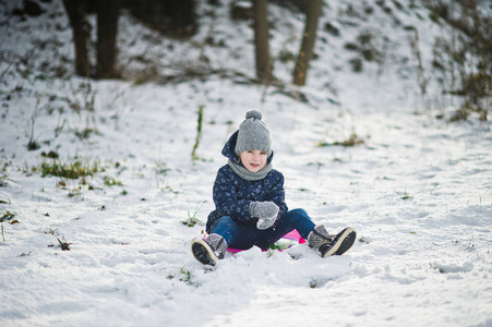 可爱的小女孩，与飞碟雪橇在户外在冬季的一天