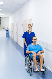 医院走廊轮椅上的外科医生和男性病人