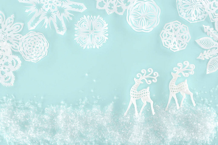 圣诞节背景与装饰雪，雪花，纸鹿隔离在浅蓝色。