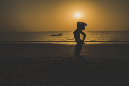 s in the sand on the seashore. Its silhouette contrasted with th