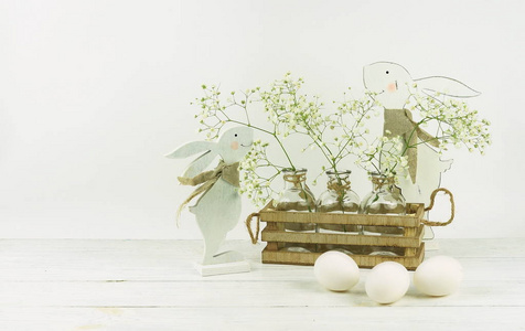 复活节彩蛋和白色木制背景上可爱的兔子。 节日装饰。 复活节快乐