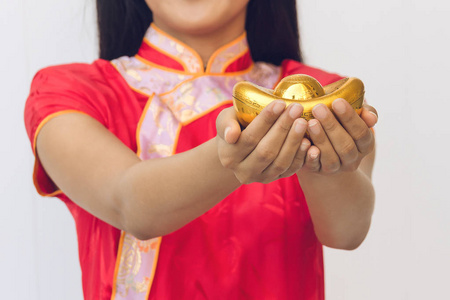 亚洲女子用旗袍捧着金子。春节