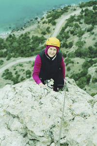 一个年轻女子用绳子从事攀岩运动