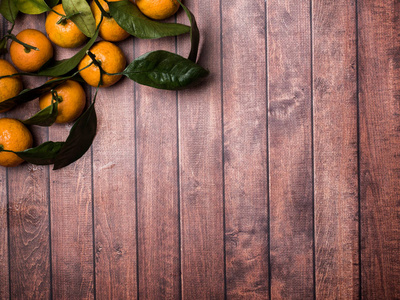 新鲜的普通话或橘色的茎和叶在一个棕色的木制背景复制空间