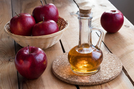 一瓶苹果醋, 在木桌子上有红苹果