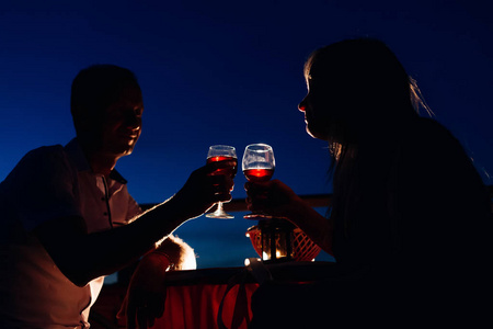 一对夫妇喝着酒，身后是夜空